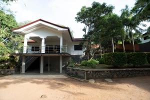 a white house with a porch and trees at Brescia villa - Your Private Escape in matara in Gandara West
