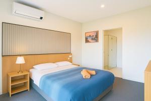 Un dormitorio con una cama grande con un animal de peluche encima. en Apollo Dream Suites, en Apollo Bay