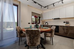 a kitchen with a wooden table with chairs and a vase of flowers at Adelda Villa in Kypseli