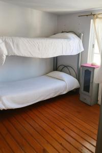 2 letti a castello in una camera con pavimento in legno di Blue house St a Buenos Aires