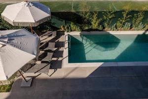 an overhead view of a swimming pool with umbrellas and a swimming pool at Adelda Villa in Kypseli