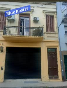 un edificio con un cartello blu di un ostello sopra un garage di Blue house St a Buenos Aires