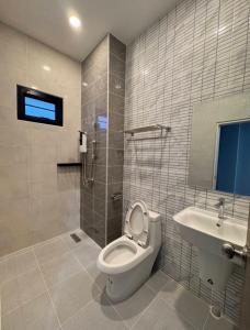 ein Badezimmer mit Toilette und Waschbecken in der Unterkunft The Breezy Hotel in Muaklek