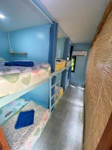 a room with two bunk beds and a hallway at Simple Hostel Phangan in Baan Khai