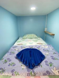a blue bedroom with a bed with a blue wall at Simple Hostel Phangan in Baan Khai +5 photos