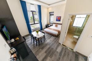 ein Hotelzimmer mit einem Bett und einem Tisch sowie einem Zimmer in der Unterkunft ROYAL DRAGON HOTEL in Da Lat