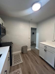 una cucina con armadi bianchi e piano di lavoro bianco di Beach 2BR Villa Sleeps 4 Trendy & Luxe a Pompano Beach