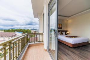 ein Schlafzimmer mit Bett und Balkon in der Unterkunft ROYAL DRAGON HOTEL in Da Lat