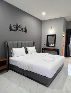 ein Schlafzimmer mit einem großen Bett mit weißer Bettwäsche in der Unterkunft The Breezy Hotel in Muaklek