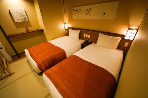 Un pat sau paturi într-o cameră la Jozankei Onsen Yurakusoan