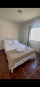a bedroom with a white bed with a window at Casa Canto de Geribá, 10 min da Praia in Búzios