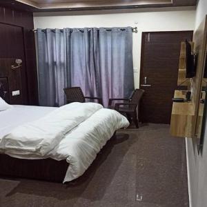 巴德里纳特The Shloka Badrinath By StayApart的一间卧室，有一张床、两把椅子和一扇窗户