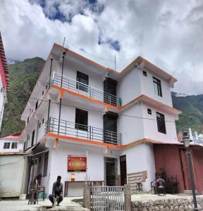 巴德里纳特The Shloka Badrinath By StayApart的坐在白色建筑前的人