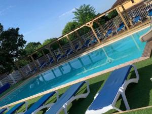 - une piscine bordée de chaises longues bleues dans l'établissement Mobil Home 27m² avec Terrasse à Limeuil - 5 personnes - API-1-52-837, à Paunat