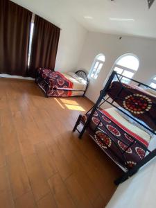 AhuatepecにあるCasa Isabella in Cuernavacaのウッドフロアのベッドルーム1室(二段ベッド2組付) +2枚の写真
