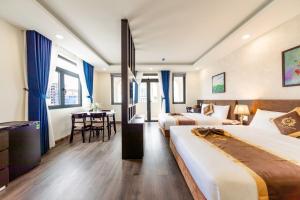ein Hotelzimmer mit zwei Betten und einem Tisch in der Unterkunft ROYAL DRAGON HOTEL in Da Lat