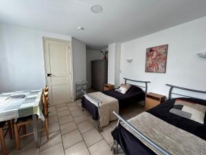 a room with two beds and a table and a door at Studio pratique avec WiFi et parking proche du centre et des Thermes - FR-1-541-184 in La Roche-Posay +2 photos