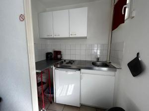 a small kitchen with white cabinets and a sink at Studio pratique avec WiFi et parking proche du centre et des Thermes - FR-1-541-184 in La Roche-Posay