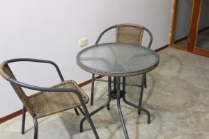 a glass table and two chairs in a room at Kala Hotel in Bocapán