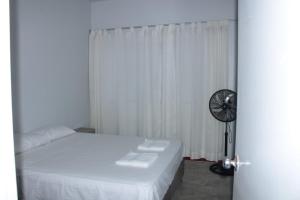 a bedroom with a bed and a window with a fan at Kala Hotel in Bocapán +4 photos