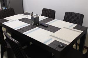 a black table with chairs and a pen holder on it at Kala Hotel in Bocapán