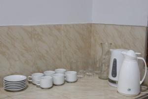 a group of white cups and plates on a counter at Kala Hotel in Bocapán