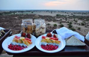 two plates of fruit on a tray with a view of the desert at Hotel Tokyo Palace in Jaisalmer