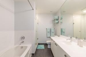 a white bathroom with two sinks and a toilet at Urban Skyline in Toronto +49 photos