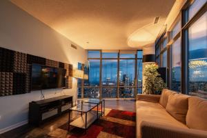 a living room with a couch and a large window at Urban Skyline in Toronto