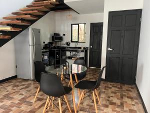 a kitchen with a glass table and black chairs at Live bambu in Caimital