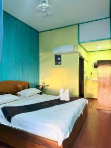 a bedroom with a large bed and a bathroom at Sompong Sunset View Guesthouse in Don Det