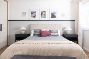 Un dormitorio con una cama grande con dos mesitas de noche. en Whitsunday Wanderluxe, en Cannonvale