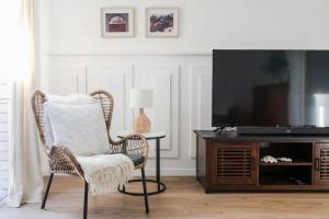 Una sala de estar con una silla de mimbre y un televisor. en Whitsunday Wanderluxe, en Cannonvale