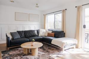 Una sala de estar con un sofá negro y una mesa. en Whitsunday Wanderluxe, en Cannonvale