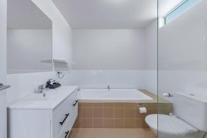 un bagno bianco con lavandino e WC di Tropical Resort Apartment a Cannonvale Altre 34 foto