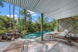 an outdoor pool with a bench and a table at Treetop Paradise Retreat with Pool in Cannonvale +17 photos
