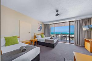 a hotel room with two beds and a view of the ocean at Ocean View Studio 14A KIDS STAY FREE in Airlie Beach +6 photos