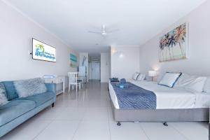 a large bedroom with a bed and a couch at Central Ocean View Studio 27a in Airlie Beach
