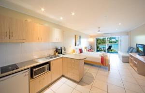 eine Küche und ein Wohnzimmer mit einem Bett und einer Küche und einem Zimmer in der Unterkunft Baybliss Escape #2 - Adults Only in Shute Harbour