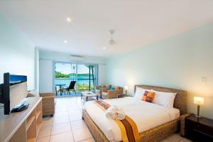 a bedroom with a large bed and a living room at Baybliss Escape #3 - Adults Only in Shute Harbour