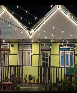a yellow house with lights on top of it at Wanderlust Homestay By StayApart in Kalimpong