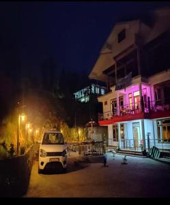 a white car parked in front of a building at night at Wanderlust Homestay By StayApart in Kalimpong +5 photos