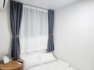 Wŏnsanjŏng달달마실 204호的卧室设有窗户、一张床和一张桌子