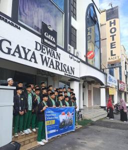 un groupe de personnes debout devant un bâtiment dans l'établissement Hotel Bajet Gaya Warisan, à Kota Bharu