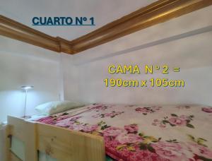 - une chambre avec un lit orné de fleurs roses dans l'établissement Centro Historico Lima - Apartamento, à Lima