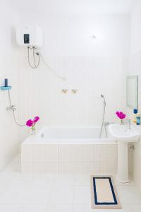 ein weißes Badezimmer mit Badewanne und Waschbecken in der Unterkunft Ununio Beach Holiday Home in Daressalam