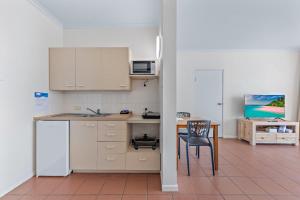 cocina con escritorio, mesa y silla en OCEAN VIEWS 10A, en Airlie Beach