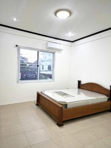 een slaapkamer met een bed in een kamer met een raam bij Vientiane Semi detached house in Vientiane