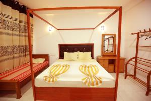 a bedroom with a four poster bed and a mirror at White Lion Paradise Dikwella in Batigama +102 photos