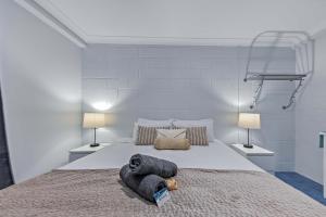 埃尔利海滩Airlie Sun & Sand Accommodation #5的一间卧室，有一张大床，配有两盏灯